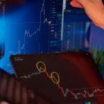 A person analyzes cryptocurrency market trends on multiple screens with graphs.